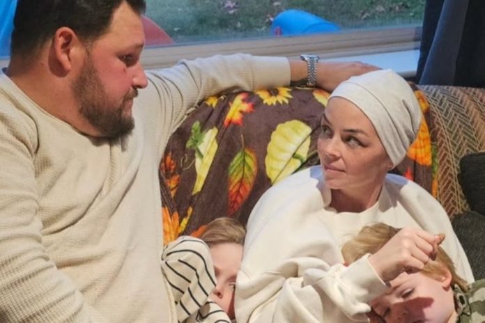 Casal com duas crianças em sofá - Metrópoles