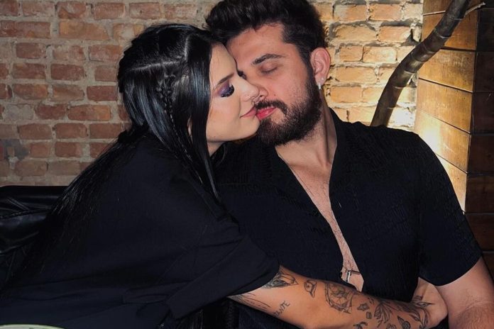 Ana Castela e Gustavo Mioto posam juntos em restaurante, ambos de looks pretos - Metrópoles