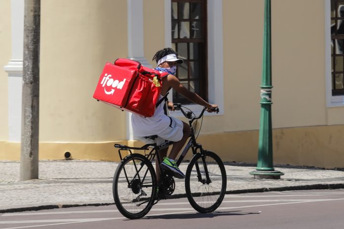 Foto colorida de entregador de ifood em cima da bicicleta - Metrópoles - Trabalho nas ruas: como a rotina afeta saúde de entregadores